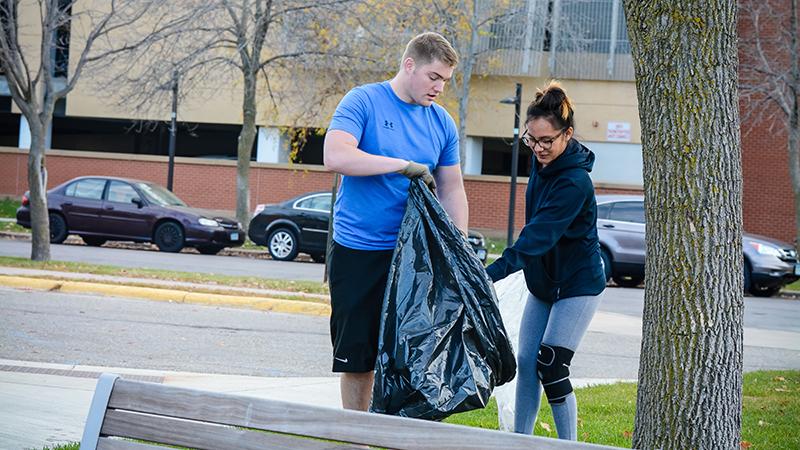 Two students picking up trash